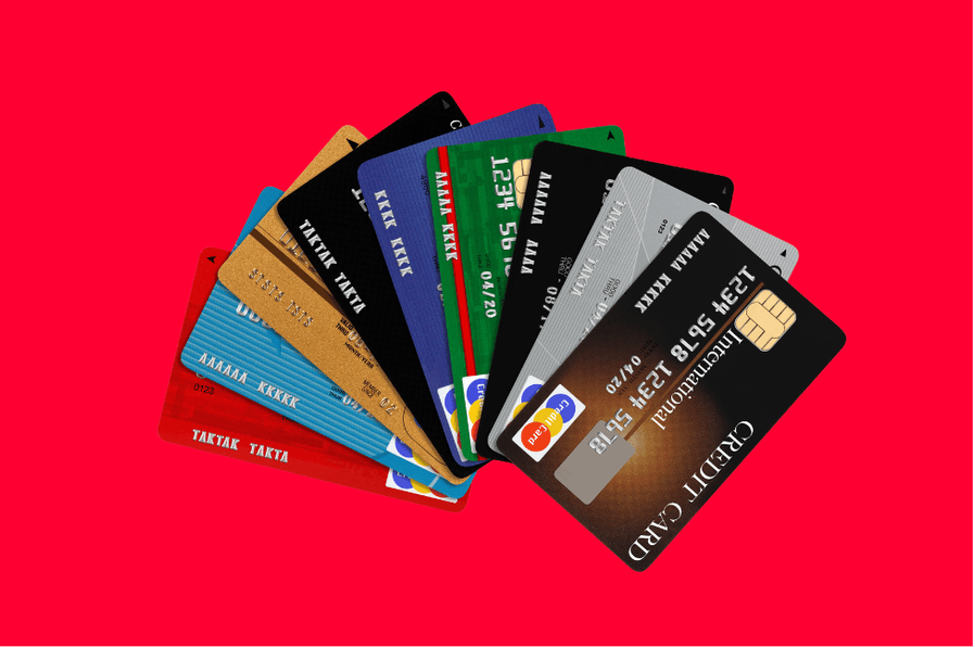 A group of different colored credit cards arranged in a fan-like shape against a red-colored background.